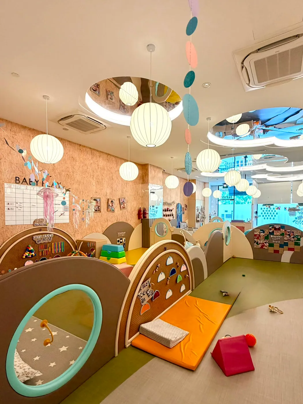 The wide infant care room with lantern lighting and cosy cot nooks