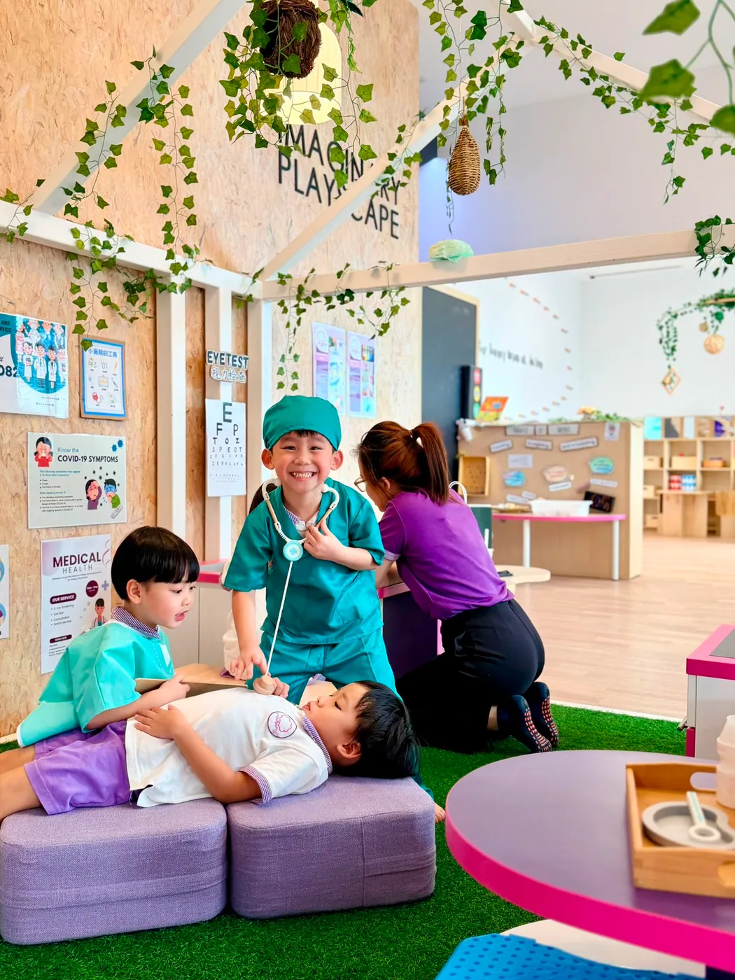Children in doctor and patient dress-up playing a clinic scene at the Imaginary Playscape